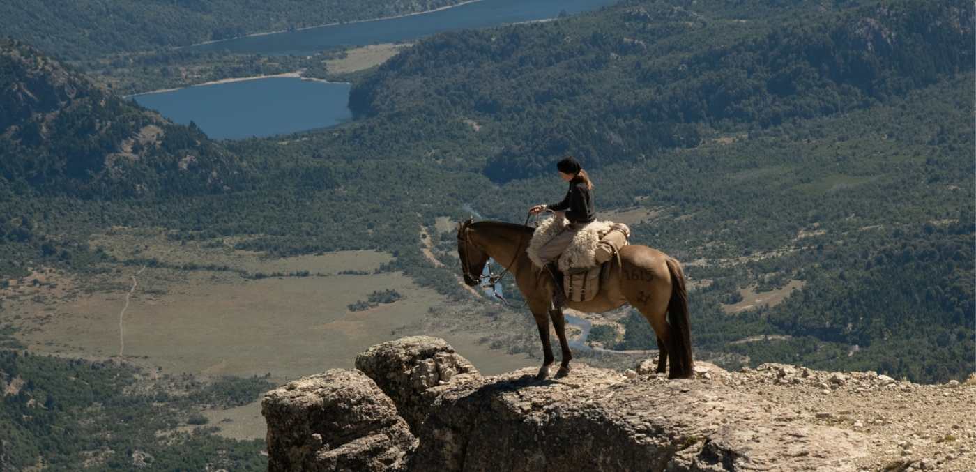 person sitting on horse at cliff edge
