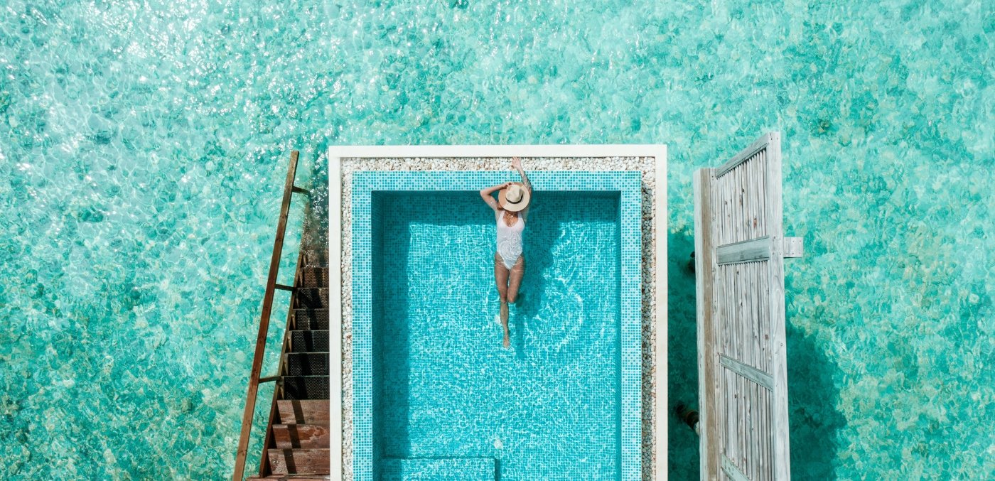 Woman laying in pool in Maldives