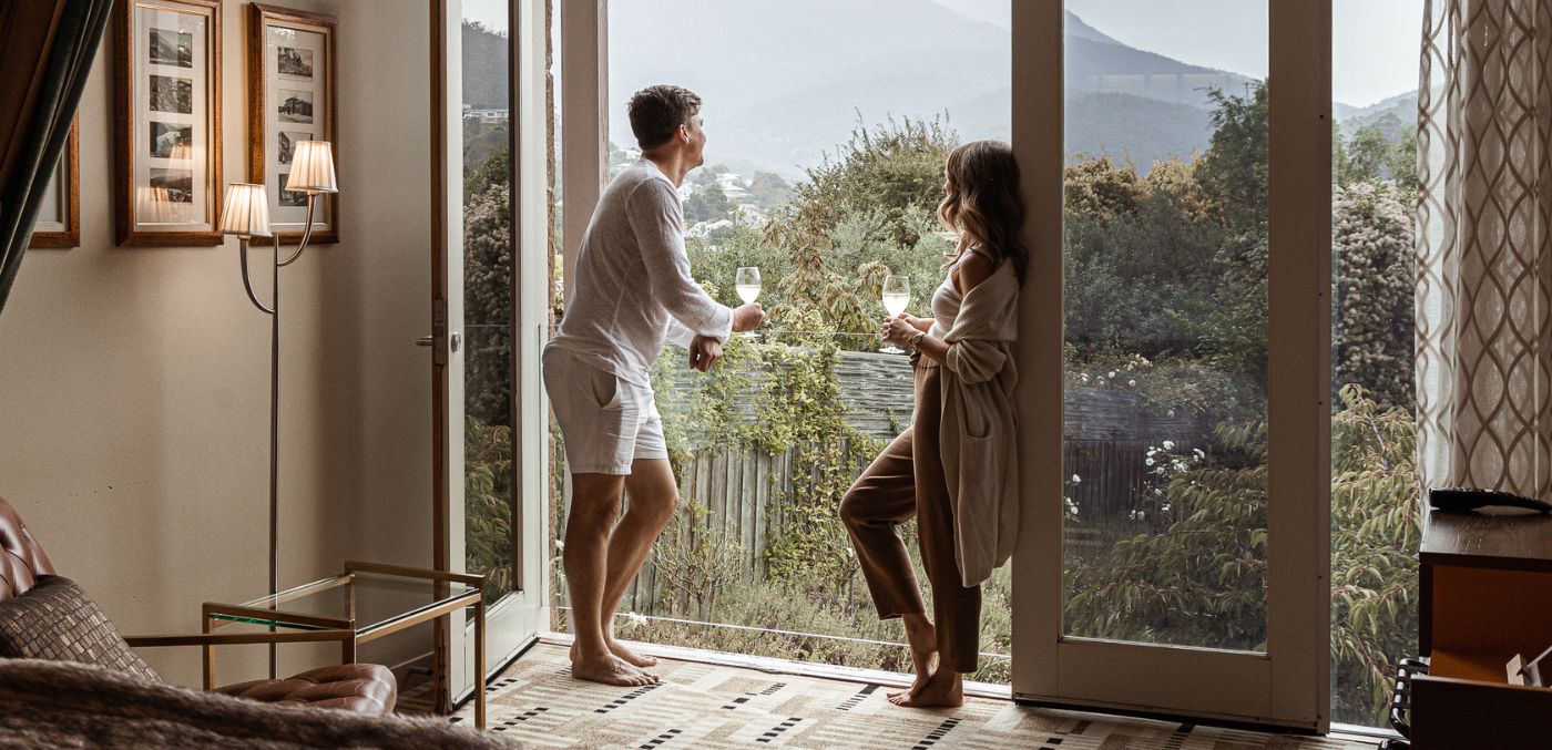 Couple standing on balcony with wine at Islington Hotel in Tasmania